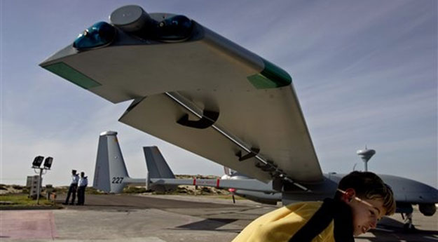 A boy walks under the wing of the world's largest drone in Palmahim Air Force Base, Israel, in March 2007 (AP Photo/Ariel Schalit)