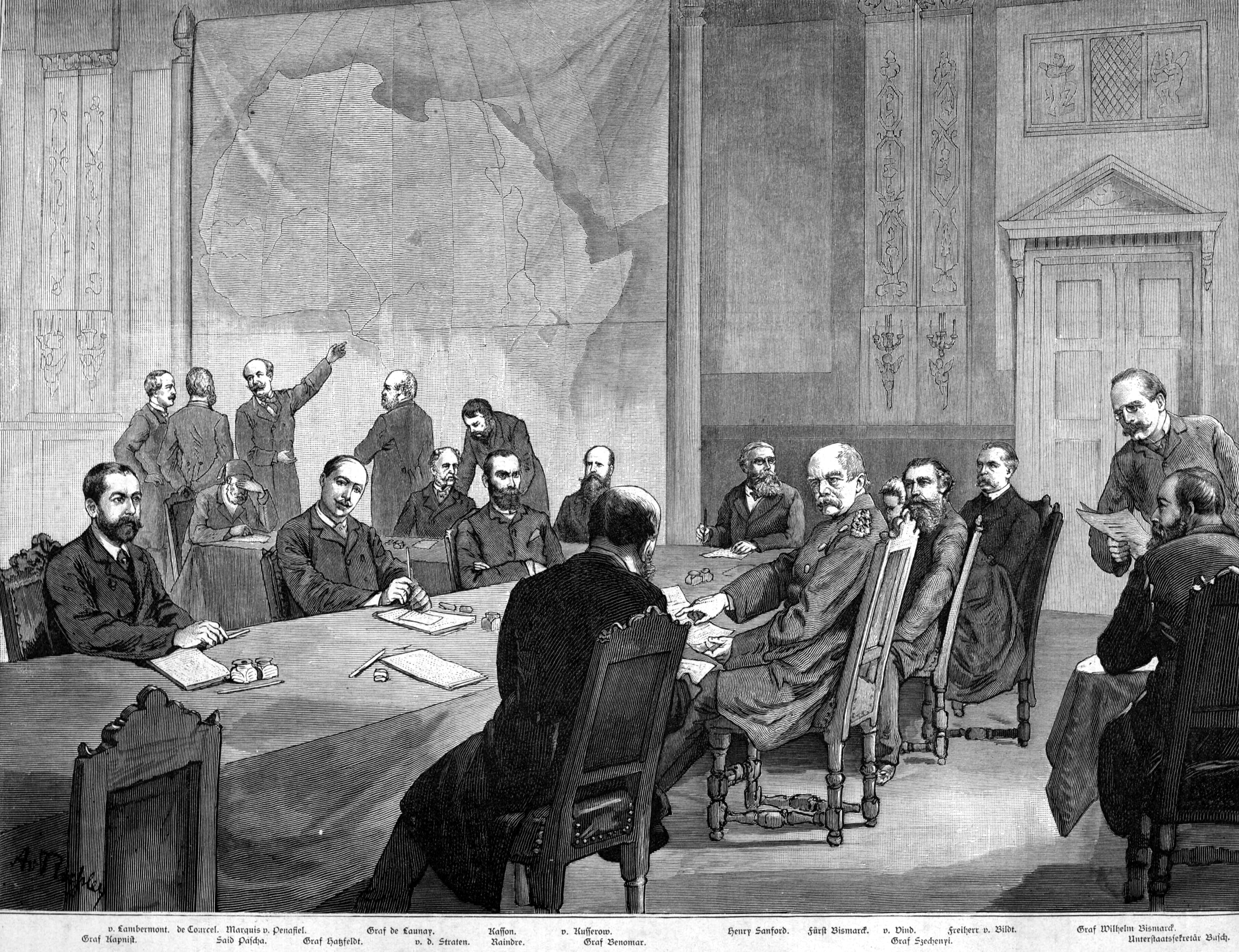 A newspaper print showing men gathered around a table at the Berlin Conference of 1884 to 1885. Several appear to be discussing a large map of Africa.